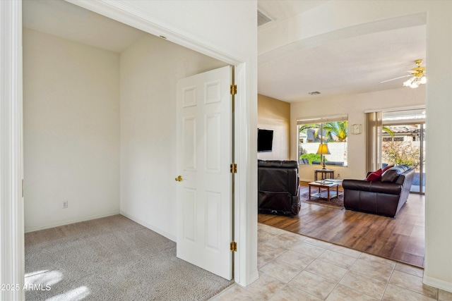 unfurnished room with light tile patterned floors, baseboards, and a ceiling fan