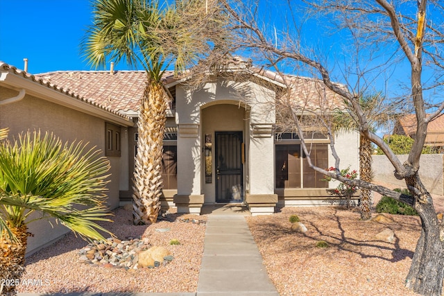 view of front of house with a tiled roof and stucco siding