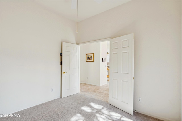 spare room featuring baseboards and light colored carpet