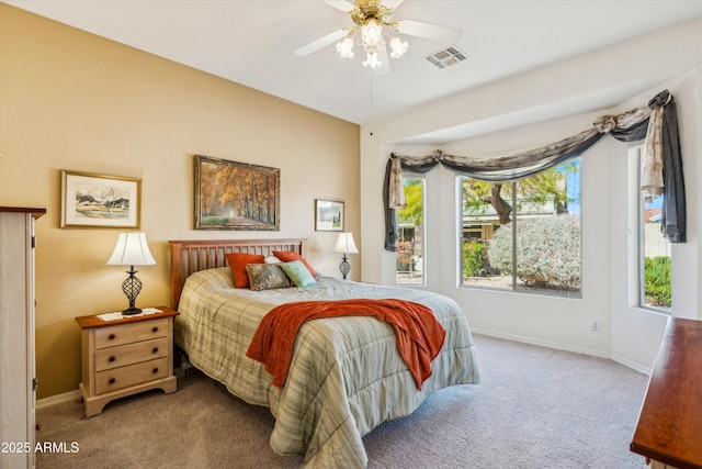 carpeted bedroom with baseboards, visible vents, and ceiling fan