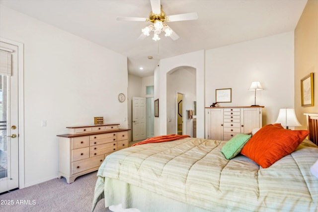 bedroom featuring arched walkways, light carpet, and ceiling fan