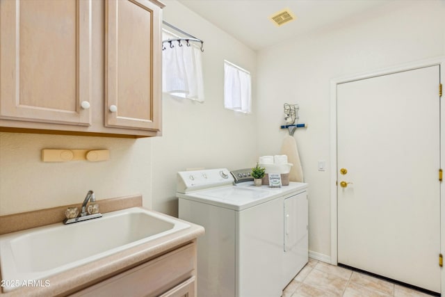 laundry room featuring light tile patterned flooring, cabinets, sink, and washer and dryer