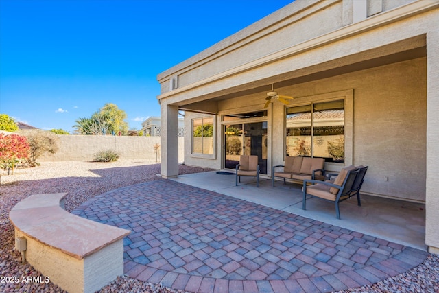 view of patio featuring an outdoor living space, fence, and a ceiling fan