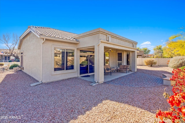 rear view of property with a tile roof, ceiling fan, fence, a patio area, and stucco siding