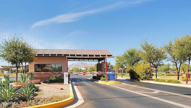 view of road featuring curbs, a gated entry, and traffic signs