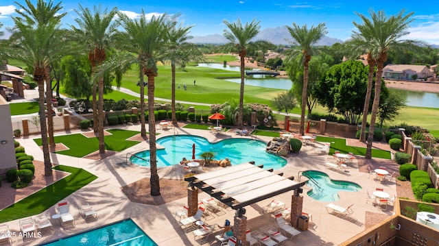 community pool with a water view, fence, golf course view, and a patio