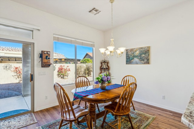 dining room featuring visible vents, baseboards, and wood finished floors