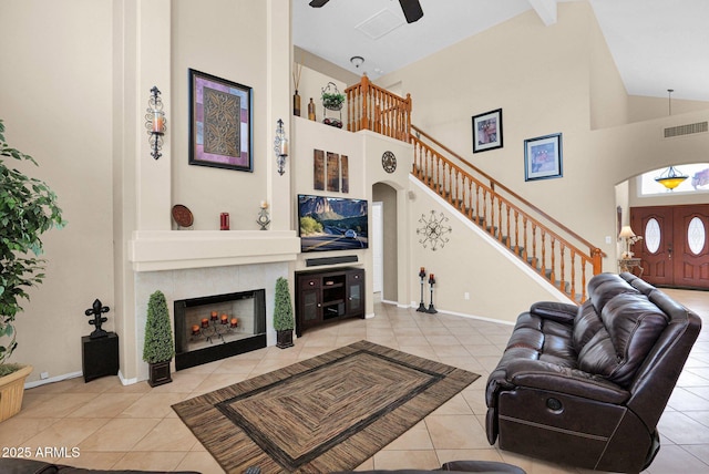 1292 N Renee Ave, Gilbert, AZ 85234 - living area featuring high vaulted ceiling, light tile patterned floors, a ceiling fan, a tile fireplace, and stairway