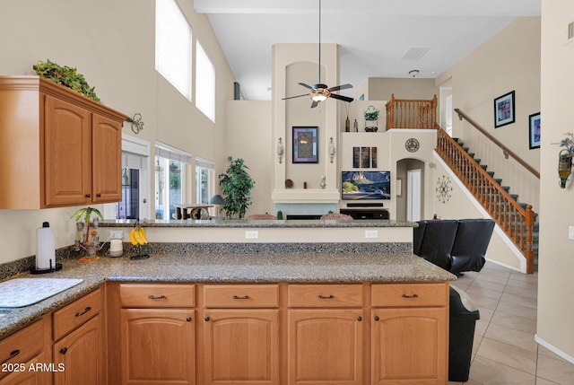 1292 N Renee Ave, Gilbert, AZ 85234 - kitchen featuring light tile patterned floors, a towering ceiling, a ceiling fan, a peninsula, and light stone countertops