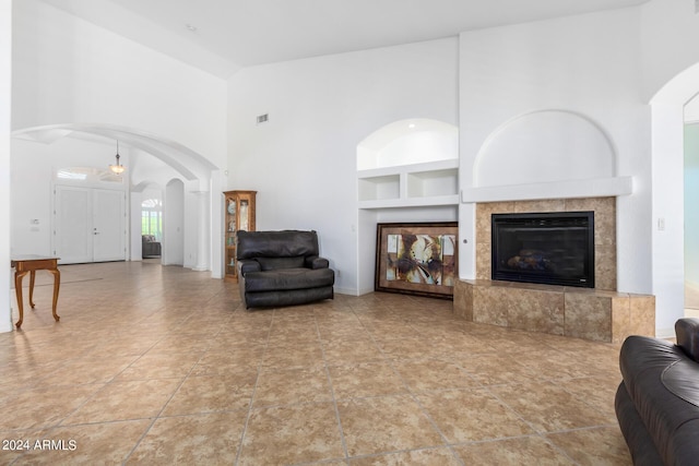 9845 E Inglewood St, Mesa, AZ 85207 - living room with visible vents, arched walkways, built in shelves, high vaulted ceiling, and a fireplace