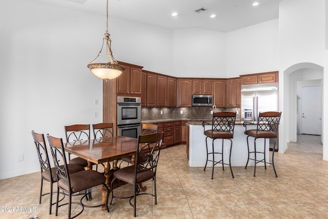 9845 E Inglewood St, Mesa, AZ 85207 - kitchen featuring visible vents, arched walkways, decorative backsplash, a kitchen island, and stainless steel appliances