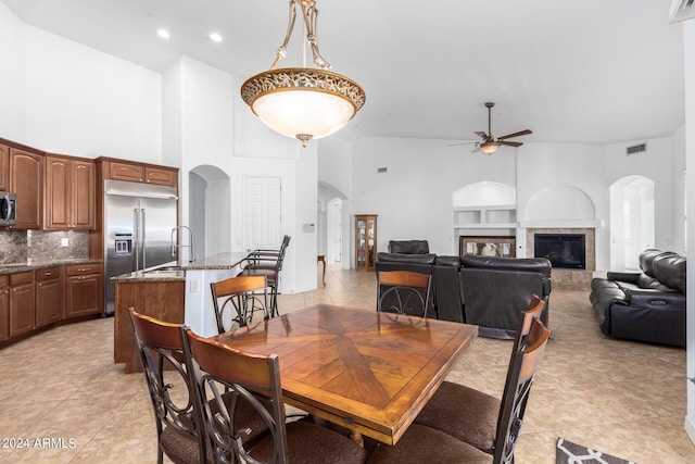 9845 E Inglewood St, Mesa, AZ 85207 - dining area with light tile patterned floors, visible vents, arched walkways, a ceiling fan, and a tiled fireplace