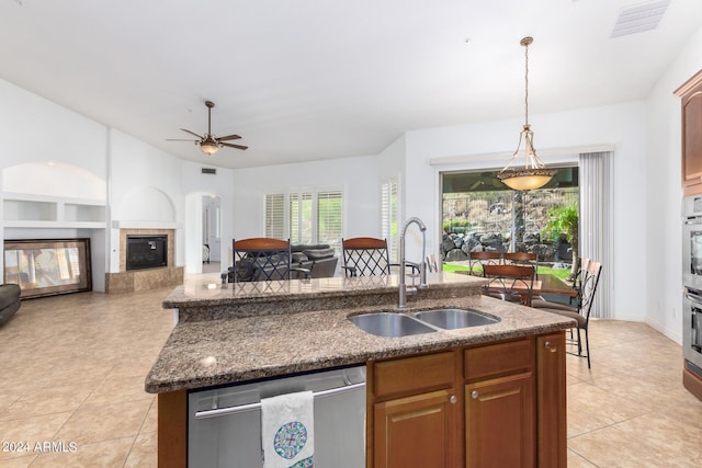 9845 E Inglewood St, Mesa, AZ 85207 - kitchen with a fireplace, light tile patterned floors, a sink, an island with sink, and dishwasher