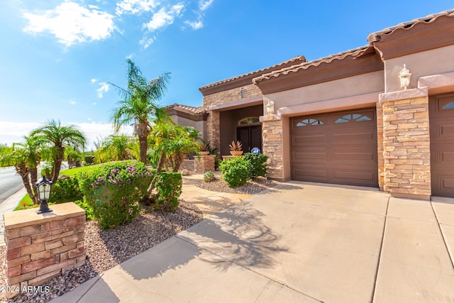 9845 E Inglewood St, Mesa, AZ 85207 - mediterranean / spanish-style house with a garage, a tile roof, driveway, stone siding, and stucco siding