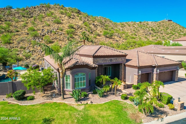 9845 E Inglewood St, Mesa, AZ 85207 - mediterranean / spanish home featuring stone siding, a tiled roof, an attached garage, and stucco siding