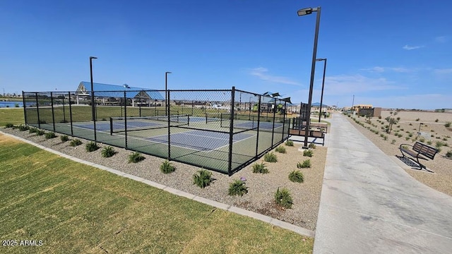 view of sport court featuring a yard and a water view