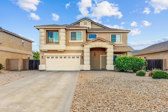 view of front of property featuring a garage, fence, and stucco siding