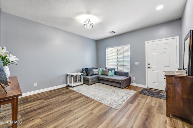 living area with visible vents, baseboards, and wood finished floors