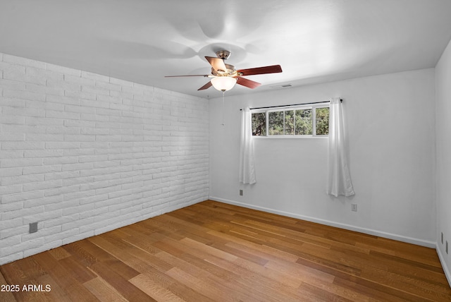 235 El Camino Grande, Sedona, AZ 86336 - empty room with a ceiling fan, brick wall, wood finished floors, and baseboards