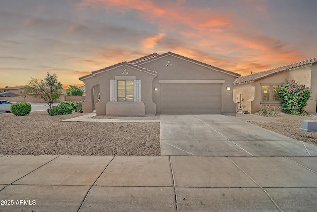 7207 W Alta Vista Rd, Laveen, AZ 85339 - mediterranean / spanish-style home with stucco siding, a garage, concrete driveway, and a tiled roof