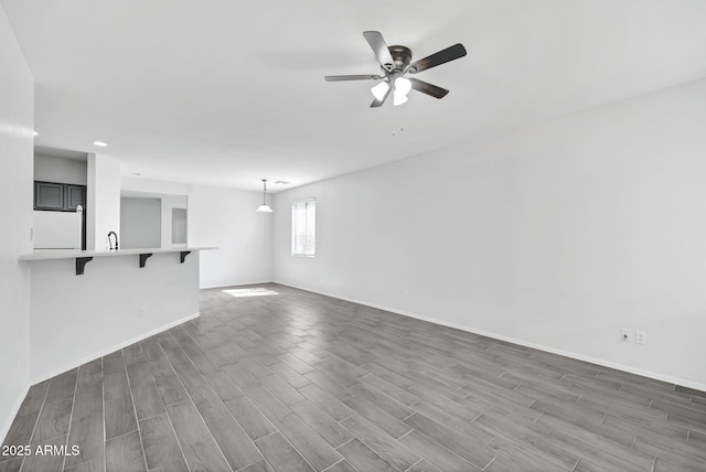 7207 W Alta Vista Rd, Laveen, AZ 85339 - unfurnished living room with wood finished floors, ceiling fan, and recessed lighting