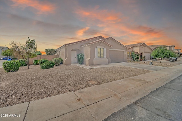 7207 W Alta Vista Rd, Laveen, AZ 85339 - mediterranean / spanish home featuring an attached garage, stucco siding, concrete driveway, and a tiled roof