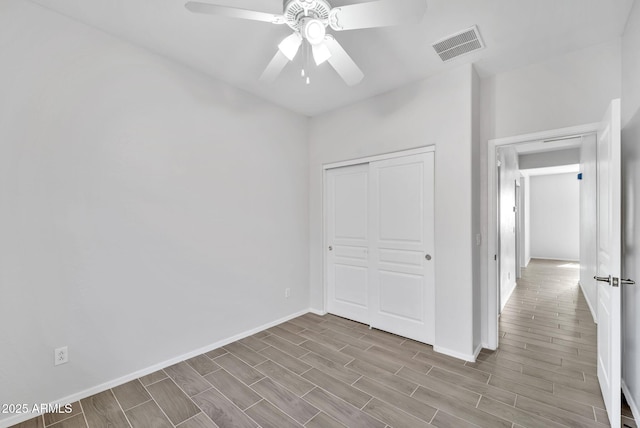 7207 W Alta Vista Rd, Laveen, AZ 85339 - unfurnished bedroom featuring wood finished floors, a closet, and ceiling fan