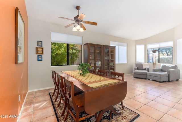 tiled dining area with lofted ceiling and ceiling fan