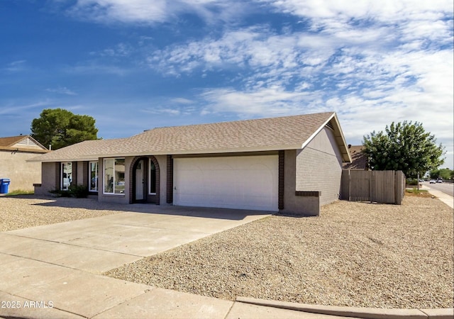 ranch-style home featuring a garage, brick siding, driveway, and fence