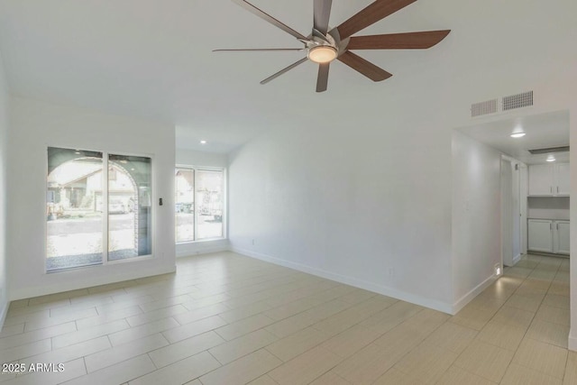 empty room with a ceiling fan, visible vents, and baseboards