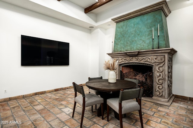 dining room with a large fireplace and baseboards