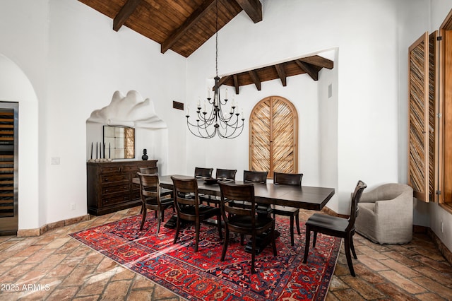 dining room with stone tile floors, baseboards, beam ceiling, wooden ceiling, and high vaulted ceiling