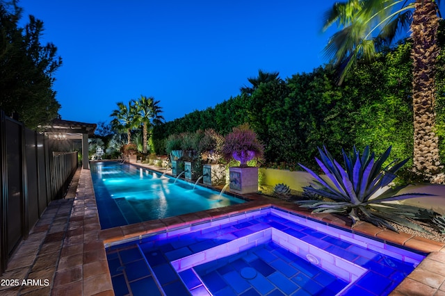 outdoor pool with fence and an in ground hot tub