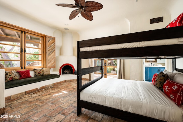 bedroom with visible vents, brick floor, and multiple windows