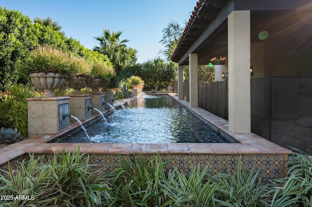 view of swimming pool featuring fence