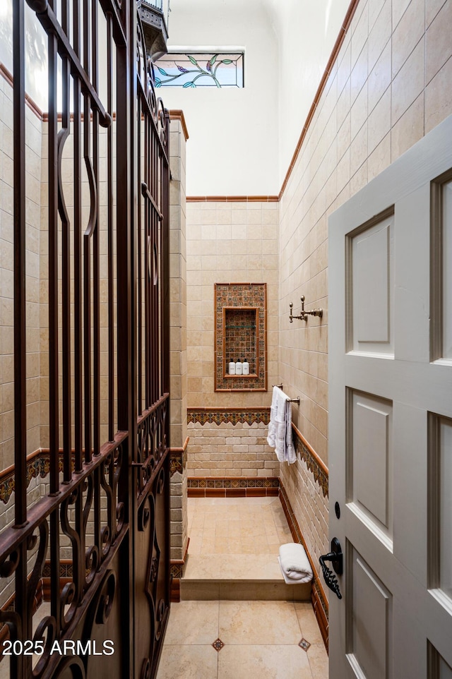 wine area with tile walls, wainscoting, and tile patterned floors