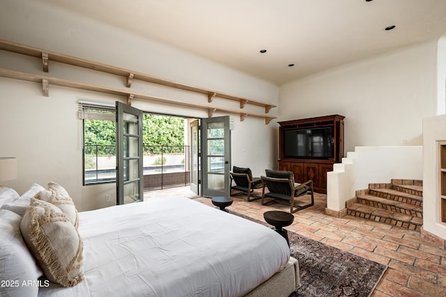 bedroom featuring brick floor and access to outside