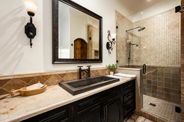 bathroom featuring a stall shower, tile walls, and vanity