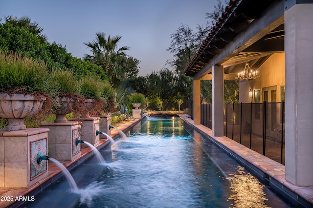 pool at dusk featuring fence and a fenced in pool
