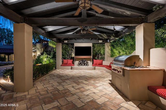 view of patio featuring an outdoor fireplace, area for grilling, a ceiling fan, an outdoor kitchen, and a gazebo