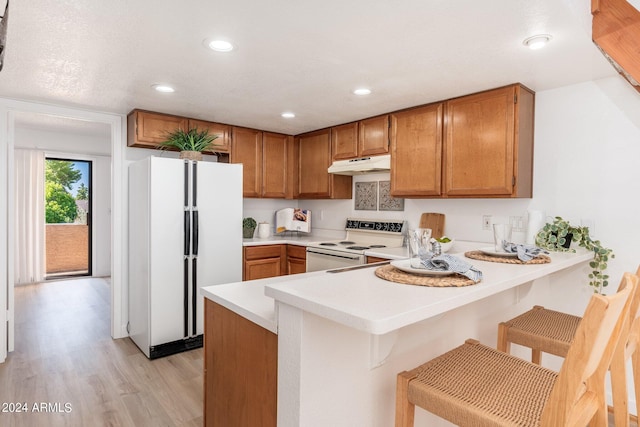 kitchen featuring light countertops, white appliances, and a peninsula