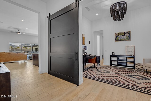 kitchen featuring stainless steel built in refrigerator, pendant lighting, light hardwood / wood-style flooring, white cabinetry, and a spacious island