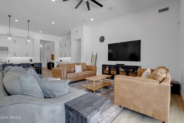 living room featuring ceiling fan and hardwood / wood-style flooring