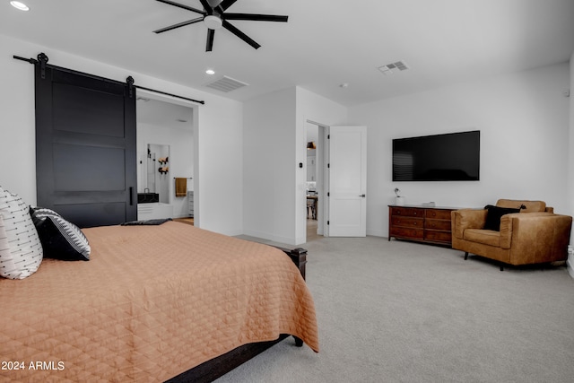 carpeted bedroom featuring ceiling fan, ensuite bath, and a barn door