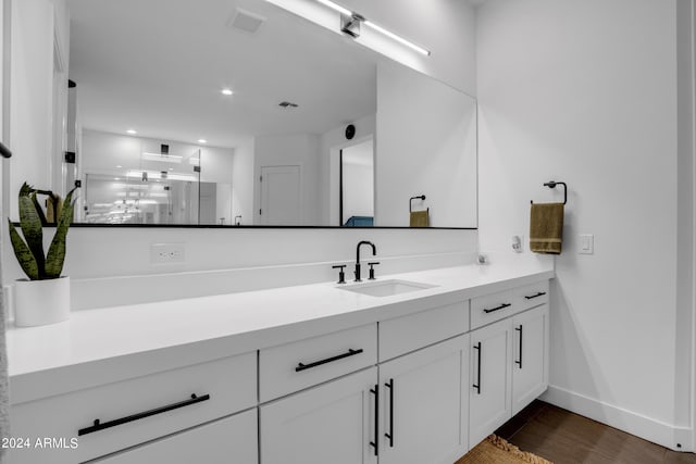 bathroom featuring walk in shower, wood-type flooring, and vanity