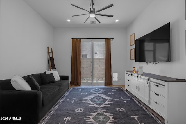 living room with ceiling fan and dark wood-type flooring