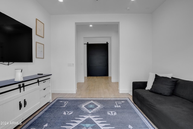 living room featuring light wood-type flooring and a barn door