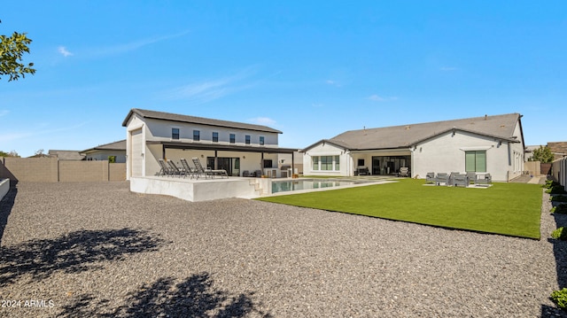 back of house featuring a lawn and a patio area