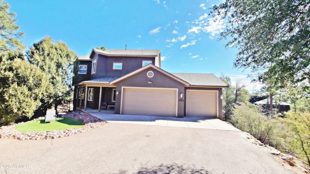 traditional home featuring a garage, driveway, a front yard, and stucco siding