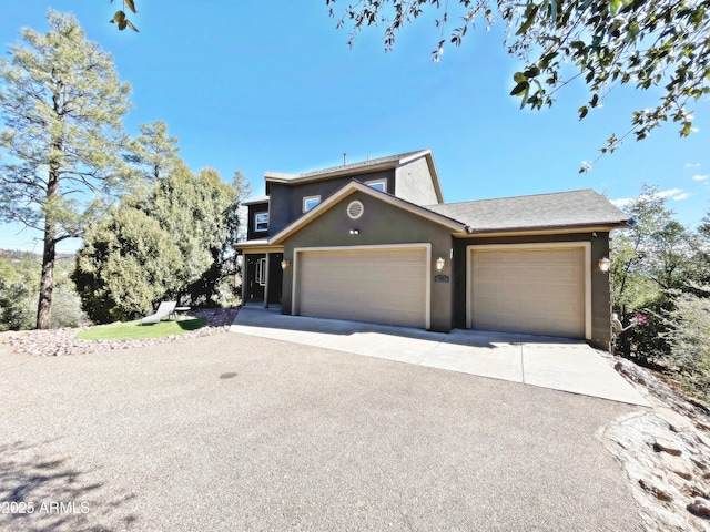 view of front of home with an attached garage, driveway, and stucco siding